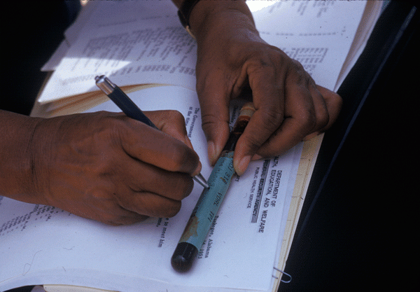 Photograph from the NLM Digitized Document Collection from USPHS Untreated Syphilis Study at Tuskegee. A person is writing on a blood collection tube.